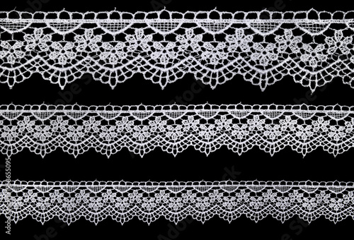 Fotografía Set of white lace ribbons on black background with delicate openwork pattern