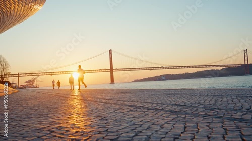 Man jogging along lisbon riverfront at sunrise