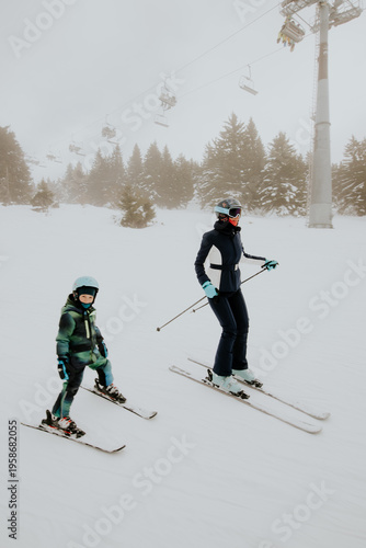 Mother and child skiing in ...