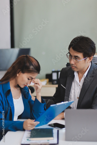 Millennial Asian stressed depressed worried thoughtful professional male businessman female businesswoman employee staff in formal business suit sitting thinking solving problem ideas in office room