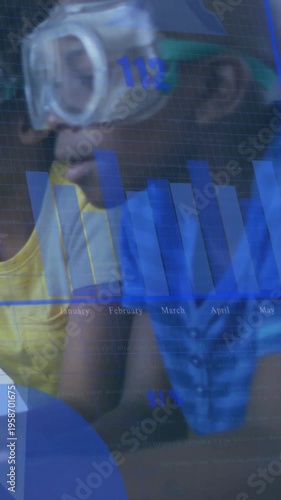 Vertical video: Pupil with goggles leaning, tracking blue overlay while peer tapping tablet for lab