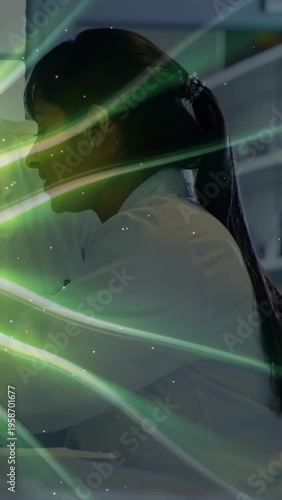 Vertical video: Woman scientist at lab bench working while green sweep crossing face revealing data