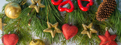 A Christmas composition. Pine and fir branches and fir cones and Christmas balls and decorations on a white background. Flat layout, top view, copy space