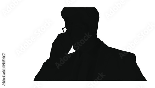 Silhouette of a person sitting down and concentrating while writing or working at a low desk surface.