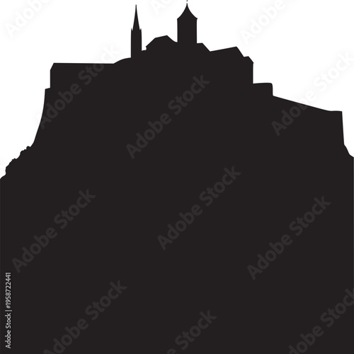 Silhouette of a hilltop fortress with a church and tower against a bright white background in stark contrast