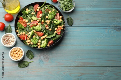 Tasty salad with chickpeas served on light blue wooden table, flat lay. Space for text