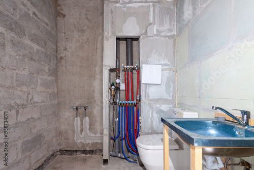 Unfinished bathroom renovation with exposed pipes, housing and cost of living crisis concept
