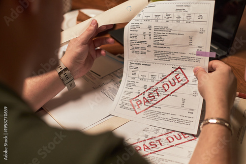 Canvastavla Caucasian young adult man holding utility bills with large past due stamps, sitt