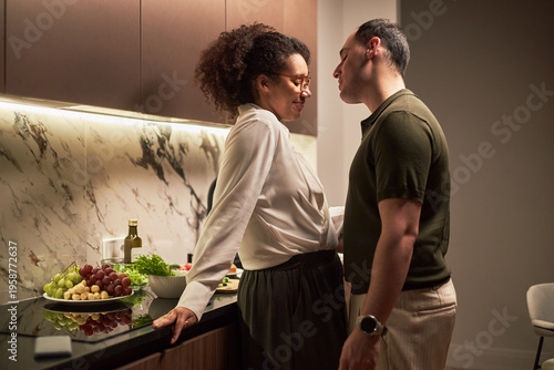 Tableau sur toile Middle aged Black woman and middle aged Caucasian man standing close together in