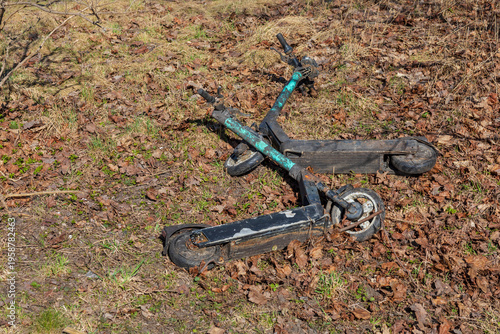 Abandoned Broken Electric Scooters on Dry Grass