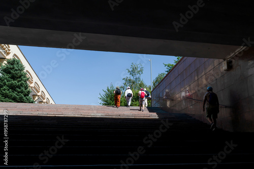 Silhouetted pedestrians walk up stairs from the Mustaqillik Maydoni subway station toward bright sunlight and blue sky, Tashkent (Toshkent), Uzbekistan (O'zbekiston)