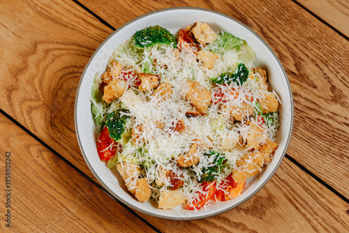 Fresh mixed salad with lettuce, broccoli, tomatoes and crunchy croutons topped with shredded parmesan