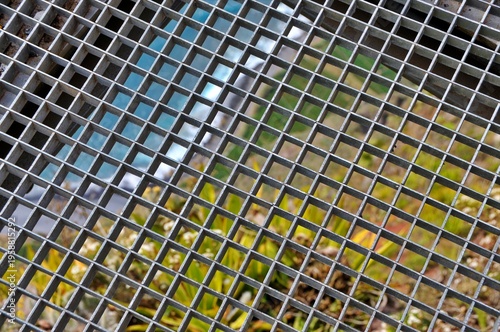 Abstract green mosaic background of urban skyscrapers with glass windows, steel structures and square patterned reflections in a modern city architecture texture