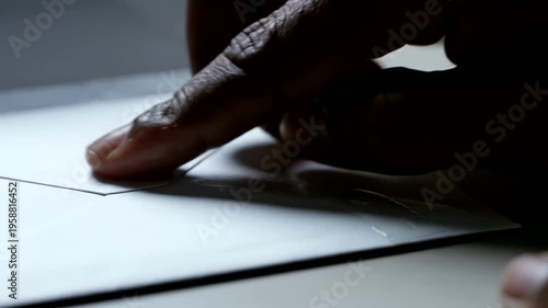 hand applying adhesive tape to paper for asset report or person sealing envelope for transaction tax report