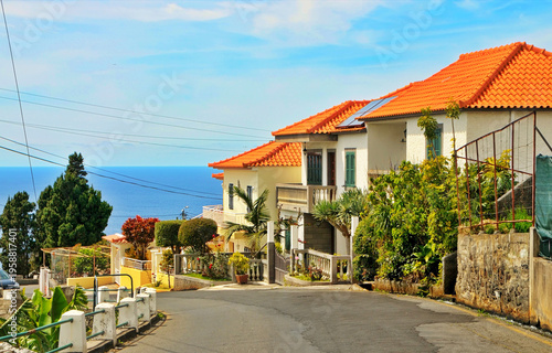 Coastal Houses With Orange Tile Roofs on a Sunny Seaside Street Overlooking the Ocean in Madeira