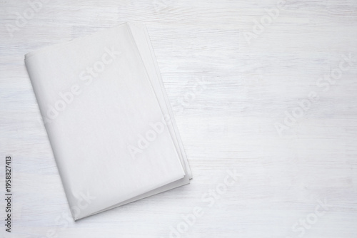 Newspaper on white wooden table, top view. Space for text