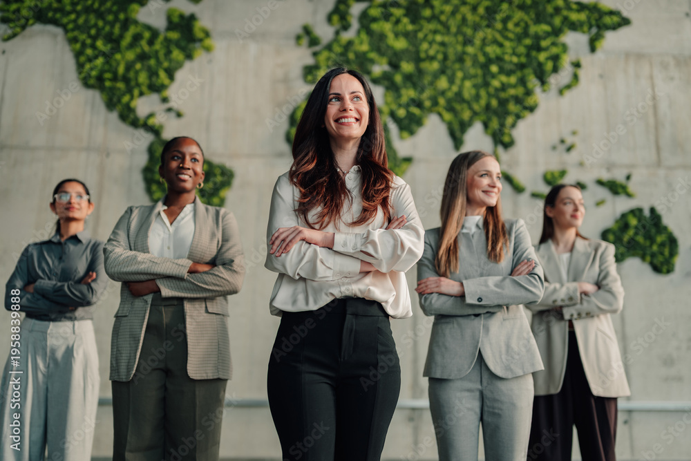 Fototapeta premium Diverse group of businesswomen standing against a green world map, symbolizing global success, empowered leadership, and collaborative team