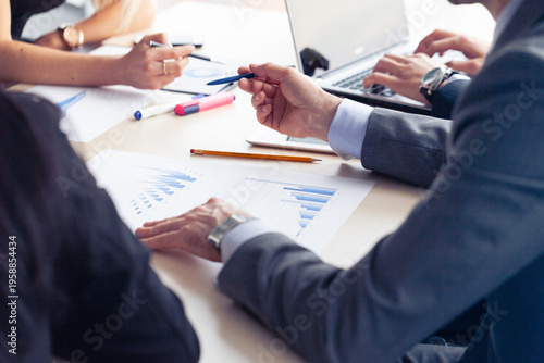 A business leader at a table looks at a chart