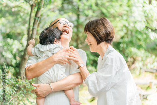Fotografie Senior couple holding their grandchild (returning home, first grandchild, visiti