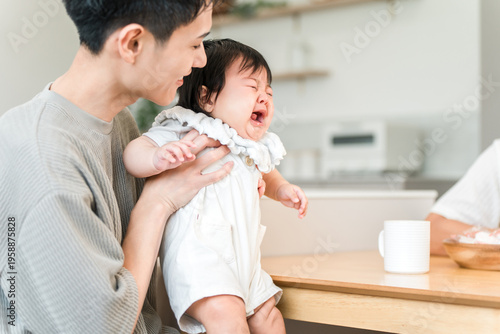 Canvas Print A father comforting a crying, fussy baby.