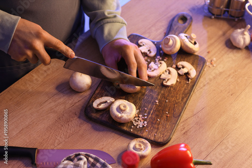 Young man cutting mushrooms...