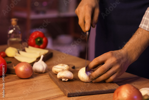 Young man cutting mushroom ...