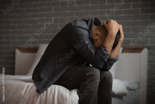 Depressed young man sitting...