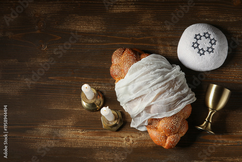 Canvastavla Traditional challah bread with wine goblet, kipa and burning candles on wooden table