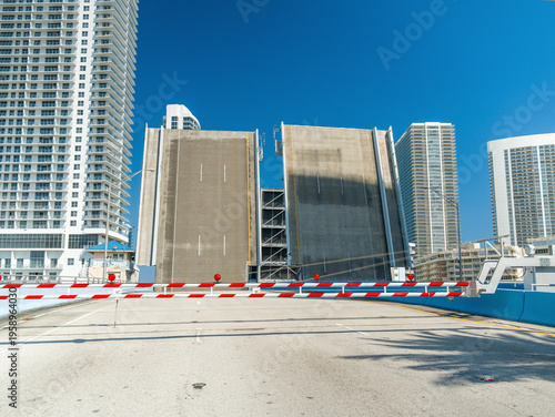 Foto Fully opened drawbridge over the water with lifting spans against the urban skyline and modern skyscrapers on a sunny day