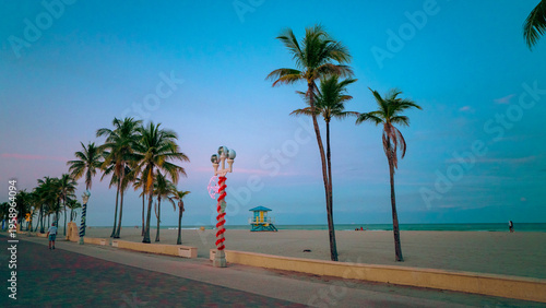 Bild auf Leinwand Hollywood Beach boardwalk at dusk with decorated lamp posts and palms