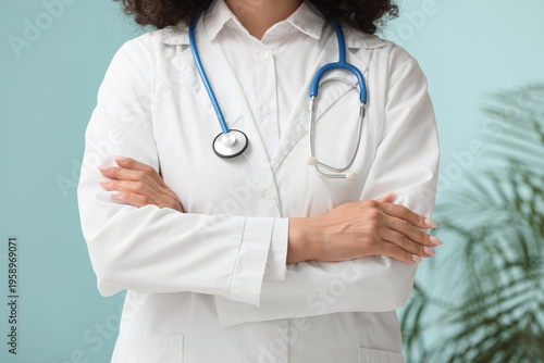 Foto Beautiful young African-American female doctor with stethoscope in clinic, close