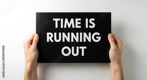 Hands holding a black sign with text time is running out on a white background