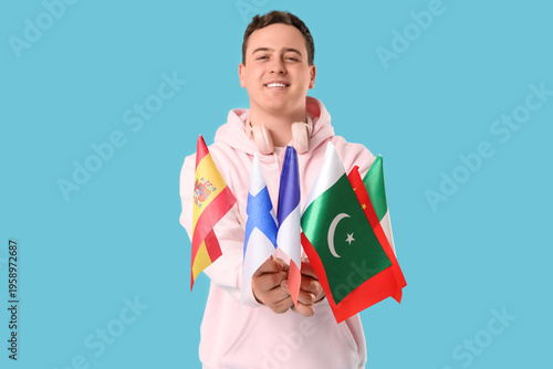 Young happy man with different flags on blue background