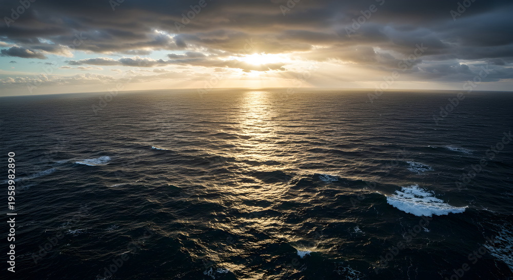 Obraz premium Majestic Ocean Sunset with Dramatic Clouds and Golden Reflections Over Calm Waters