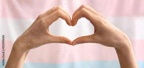 Foto Female hands in shape of heart and transgender flag