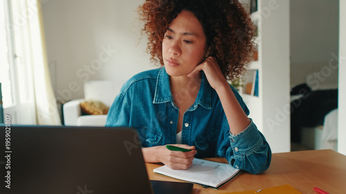Thoughtful Woman Working At Home On Laptop