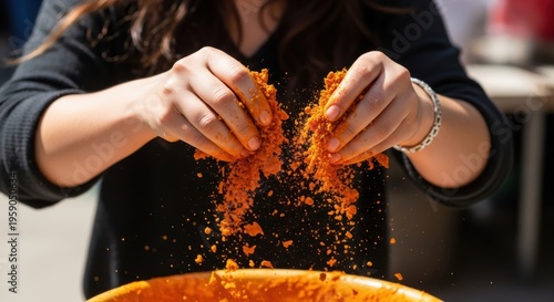 Person sifting orange powder over bowl