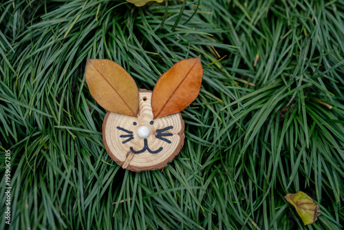 Wood slice rabbit autumn leaf ear nature craft eco friendly art handmade decoration green grass background playful face fall season creative design rustic style wood slice rabbit