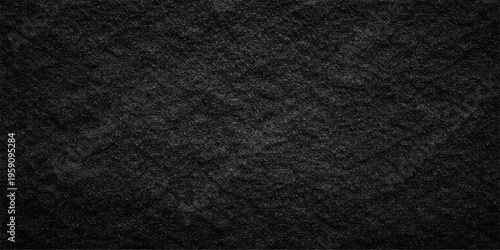 A dark textured surface features a detailed black and white fabric pattern and rough black leather material with a macro grunge textile design for a grey cloth backdrop