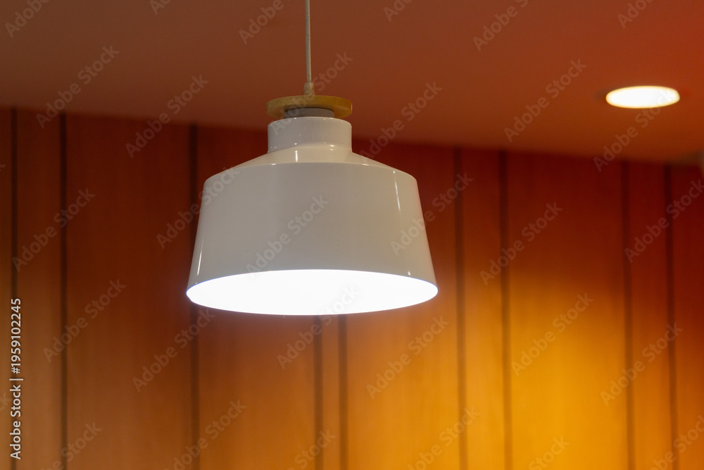 Obraz premium white hanging steel lamp on wooden wall background.
