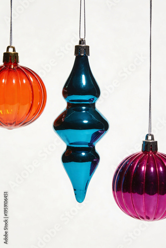 Orange Sphere Blue Conical and Purple Ball Christmas Ornaments Hanging on Light Background Illustration