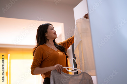 Cuadro en lienzo Woman choosing clothes from closet for morning routine