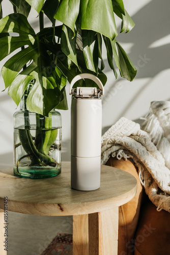 Wallpaper Mural Beige water bottle sits on end table next to tropical plant Torontodigital.ca