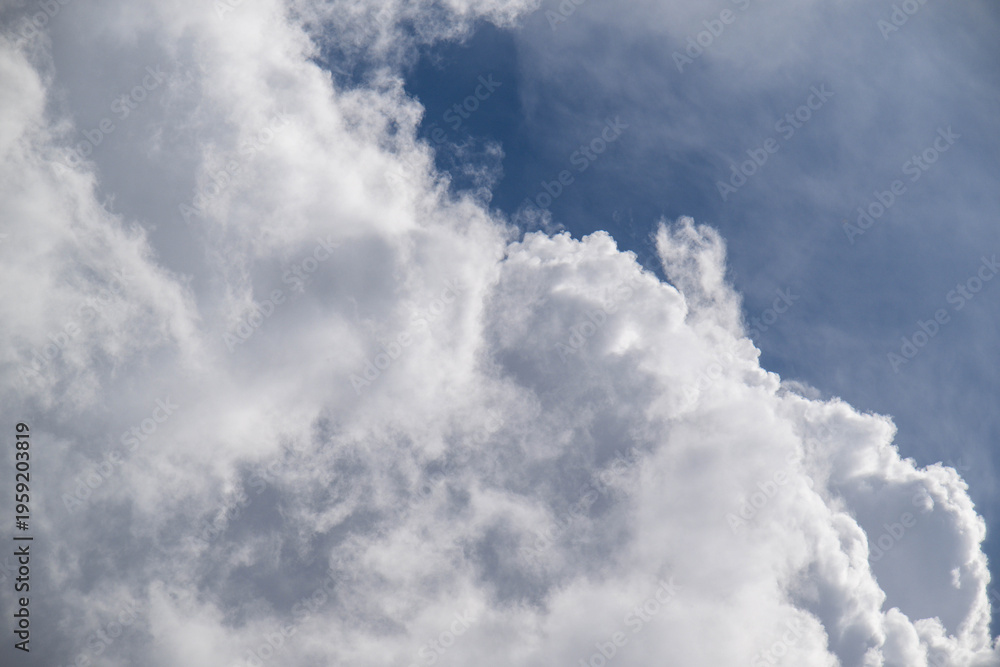 Obraz premium Dramatic sky scene featuring voluminous clouds against a vibrant blue background