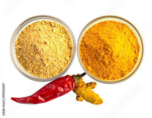 Two glass bowls of ground spices, a red chili pepper, and turmeric root
