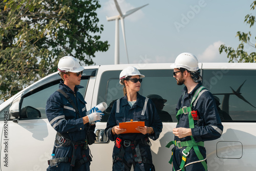 Wind turbine worker team clean energy discussion for sustainability wind energy project safety outdoors near white vehicle