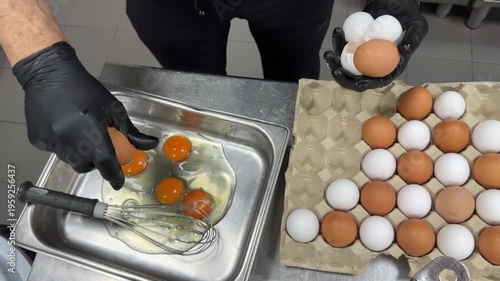 Chef cracking fresh chicken eggs into a bowl for scrambled eggs