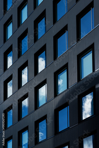 Modern glass buildings with reflection of cloud and blue sky background. Business skyscrapers in the Financial District, Sendai Downtown.