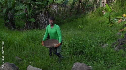 A man carrying a big stone 