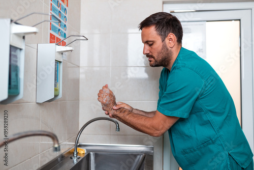 Obraz na płótnie Surgeon washing hands and arms at scrub sink before medical surgery